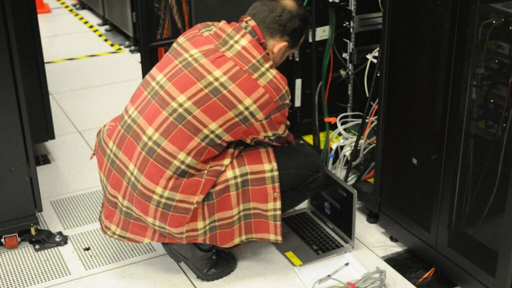 Technician working near a server rack during infrastructure migration planning